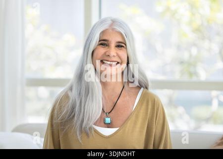 Headshot portrait of middle-aged woman with long gray hair Stock Photo