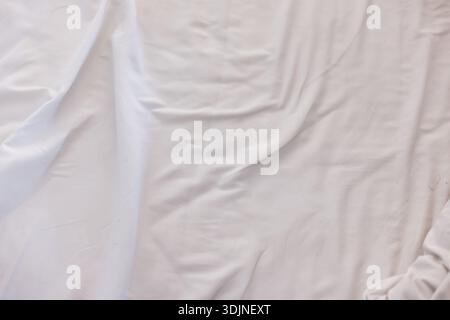 Soft white fabric texture background of wrinkled and crumpled cotton sheet. abstract surface provides clean and calm backdrop, perfect for minimalist Stock Photo