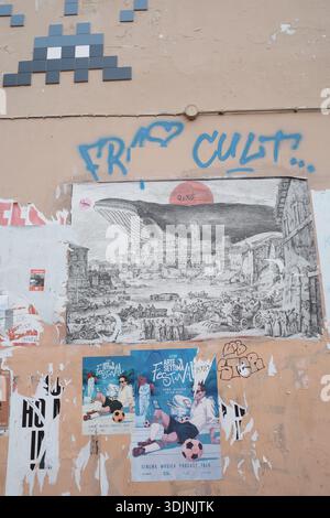 Street wall in Italy featuring various artworks and posters. Stock Photo