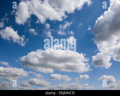 Beautiful blue sky filled with white fluffy cumulus clouds on a bright sunny day Stock Photo