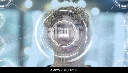 Smiling man wearing dark top presenting AR HUD in modern office, laptop icon displaying Stock Photo