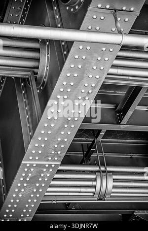Close-up of metal beams and riveted steel structure forming an industrial architectural pattern. Abstract detail of construction elements with geometr Stock Photo