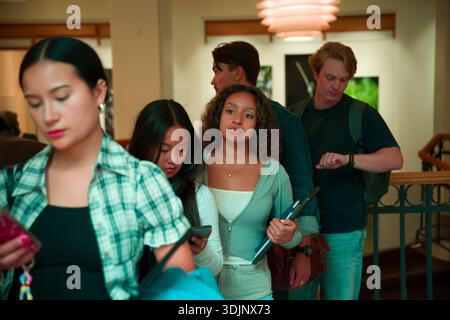 Young adult students waiting in line at college campus Stock Photo
