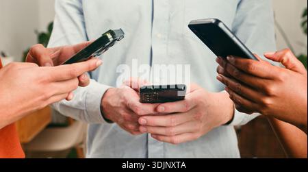 Three People Using Smartphones in a Casual Business Setting, Collaboration and Tech Focus Stock Photo
