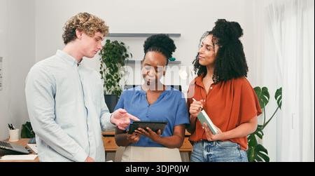 Three Professionals Collaborating in Modern Office Using Tablet for Teamwork and Learning Stock Photo