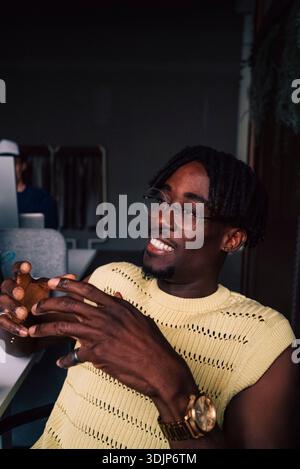 Smiling male tech expert with braided hair gesturing while communicating in office Stock Photo