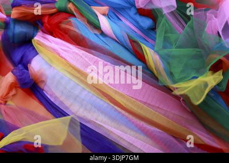 Vibrant, colorful abstract background of sheer textile and fabric. This joyful, festive rainbow of material with soft texture creates beautiful and de Stock Photo