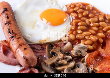 Full English breakfast with fried egg, bacon, sausages and beans isoalted on white background Stock Photo