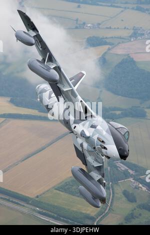 Hawker Hunter F58 aircraft flies in a banking turn during an air-to-air sequence at the Royal International Air Tattoo 2019. Powered by a Rolls-Royce Avon turbojet, the aircraft displays its swept-wing configuration and classic jet fighter profile. The close-up view shows cockpit canopy, fuselage, and wing surfaces of aircraft ZZ191 as it participates in the RIAT flying display. Stock Photo