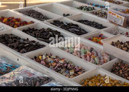 A vibrant market stall in Spain displaying a wide variety of pick-and-mix candies, a diverse assortment of sweets in various shapes, colors, and textu Stock Photo