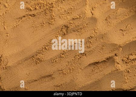 A high-angle macro photo of a nanostructured powder of medicinal herbs, showing the rough, uneven texture of a fine, dry, light brown or ochre-colored Stock Photo