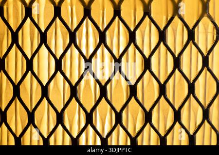 A close-up, front view shows an industrial air filter with diamond-shaped facets against a yellow background. Stock Photo