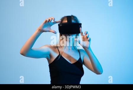 Female engineer interacting with virtual interface using VR headset, high technology innovation and immersive digital experience Stock Photo