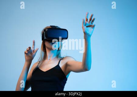 Virtual reality interaction with woman using VR headset, immersive experience and modern digital technology Stock Photo