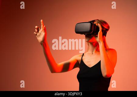 Female technology specialist wearing VR headset while interacting with virtual interface, futuristic innovation and immersive digital experience Stock Photo