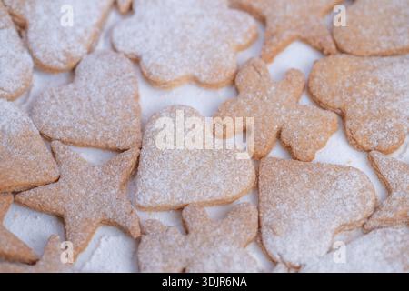 powdered sugar cookies ready for gifting, assorted shapes for present boxes, cozy market stall vibe, sustainable wrapping idea, homemade charm Stock Photo