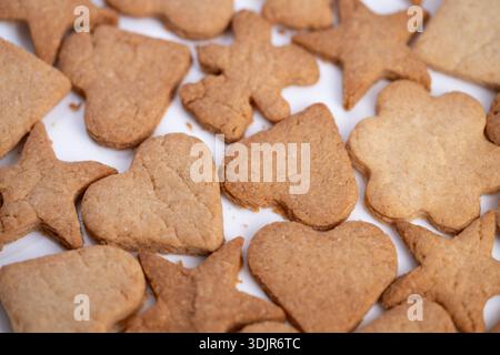 playful heart star and toy shaped cookies for childrens party, crunchy texture and friendly silhouettes scattered on white for upbeat celebration imag Stock Photo