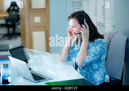 Professional woman interacts with agentic AI hologram and whiteboard. Innovation, future of work, and digital transformation concept. Real people. Stock Photo