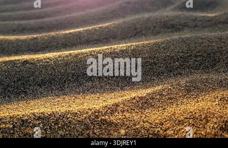 Close-Up of Wind-Rippled Sand Structure creating natural sand waves with Contrasting Evening Sun Shadows on Gran Canaria Island Stock Photo