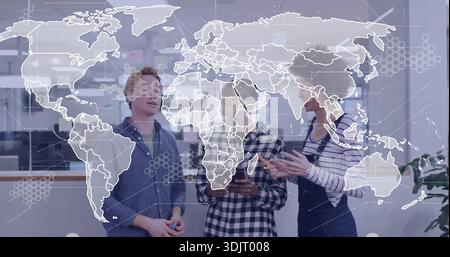 Discussing three colleagues in casual attire collaborating around tablet in office, with glass map Stock Photo