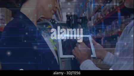 Checking tablet, worker reviewing logistics in warehouse aisle, showing HUD, blazer, vest, hard hat Stock Photo