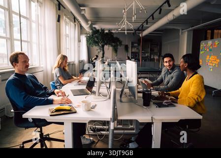 Team of business professionals working in tech hub Stock Photo