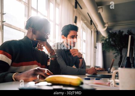 Focused male tech professionals working in office Stock Photo