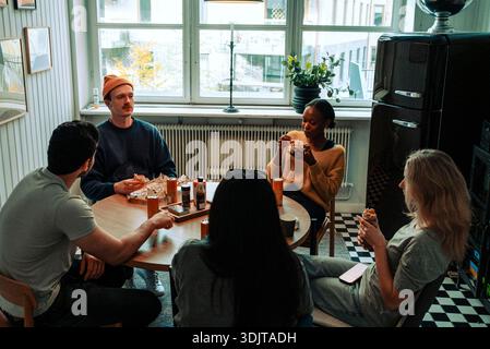 High angle view of tech experts group having lunch while sitting in cafeteria at office Stock Photo