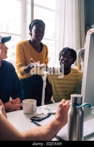 Female business expert discussing ideas with colleagues in startup office Stock Photo