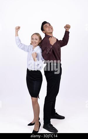 Young business couple celebrating success with hands raised Stock Photo