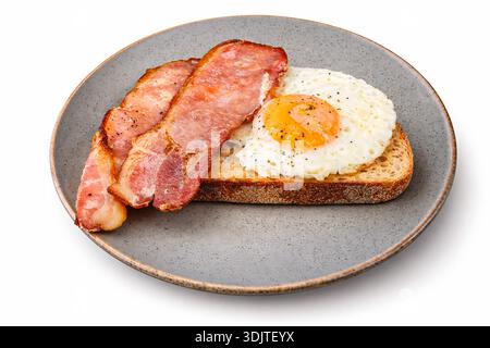 Fried egg and grilled bacon on toasted sourdough bread. *Original photograph by the contributor, digitally modified using AI tools  Stock Photo