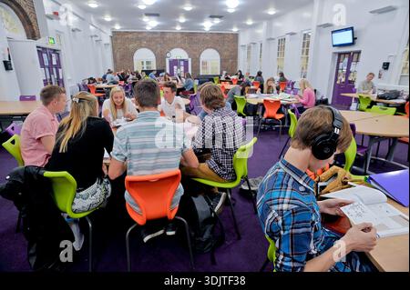 Secondary school sixth form students engaged in self-guided learning in the school library. Stock Photo