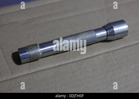 A small metallic used and dirty flashlight Stock Photo