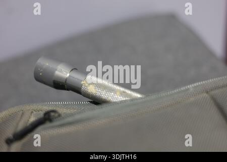 A small metallic used and dirty flashlight Stock Photo