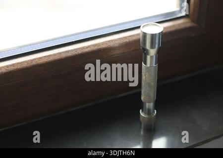 A small metallic used and dirty flashlight Stock Photo