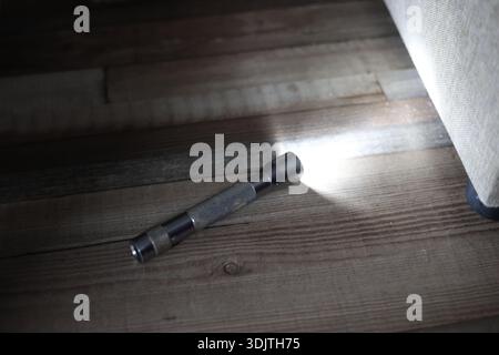 A small metallic used and dirty flashlight Stock Photo
