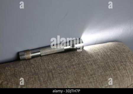 A small metallic used and dirty flashlight Stock Photo