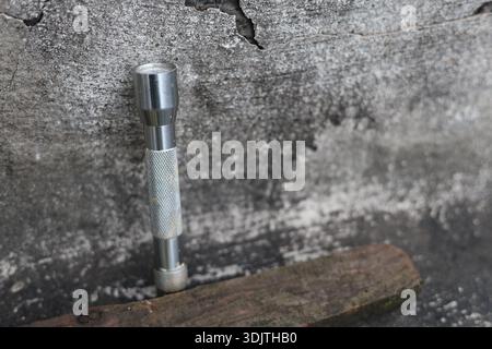 A small metallic used and dirty flashlight Stock Photo