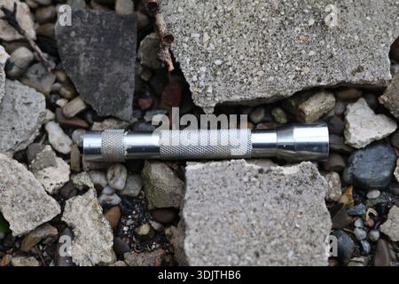 A small metallic used and dirty flashlight Stock Photo