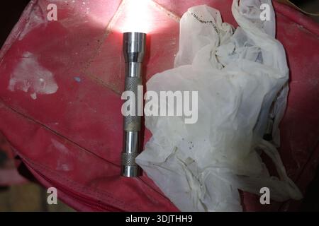 A small metallic used and dirty flashlight Stock Photo
