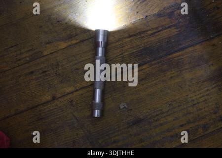 A small metallic used and dirty flashlight Stock Photo