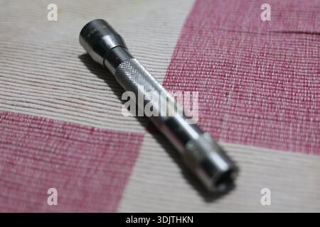 A small metallic used and dirty flashlight Stock Photo