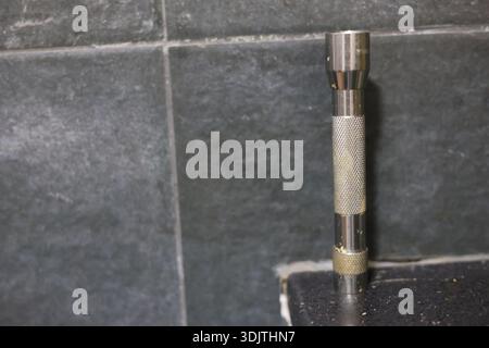 A small metallic used and dirty flashlight Stock Photo