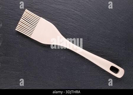 Silicone pastry brush on slate stone, close-up, top view Stock Photo