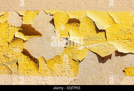 Cracked grunge yellow stone wall as background texture Stock Photo