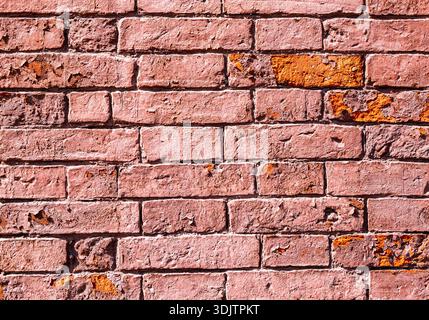 Old weathered red brick wall as creative background. Rough bricks masonry with seams as texture Stock Photo