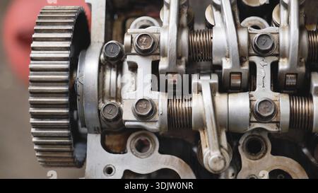 Car engine close up view showing gears, valves, springs, and cylinder head for repair Stock Photo