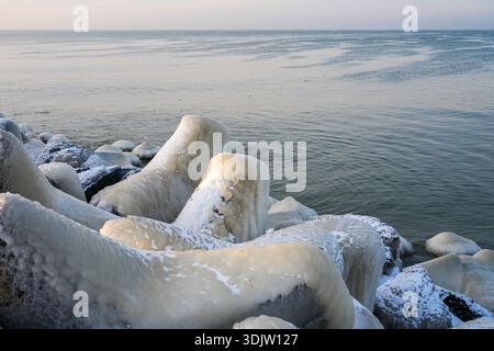 Ice-covered breakwater rocks on the Baltic Sea coast in Liepaja during a calm winter morning Stock Photo