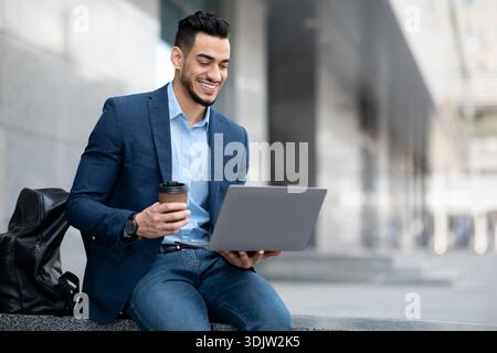 Positive project manager sitting next to business center with laptop Stock Photo