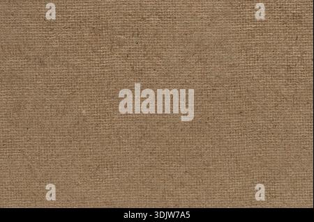 Piece of natural burlap fabric is spread out on a flat surface showing its texture and pattern clearly in a simple setting. Stock Photo
